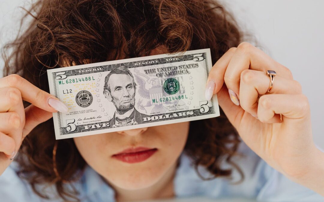 Woman Covering Her Face with a Dollar Bill