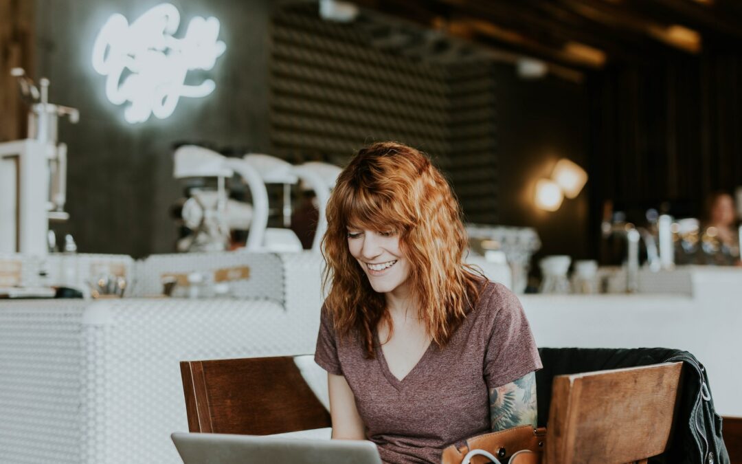 Une entrepreneure motivée, regardant son ordinateur avec détermination dans un lieu lumineux et inspirant.